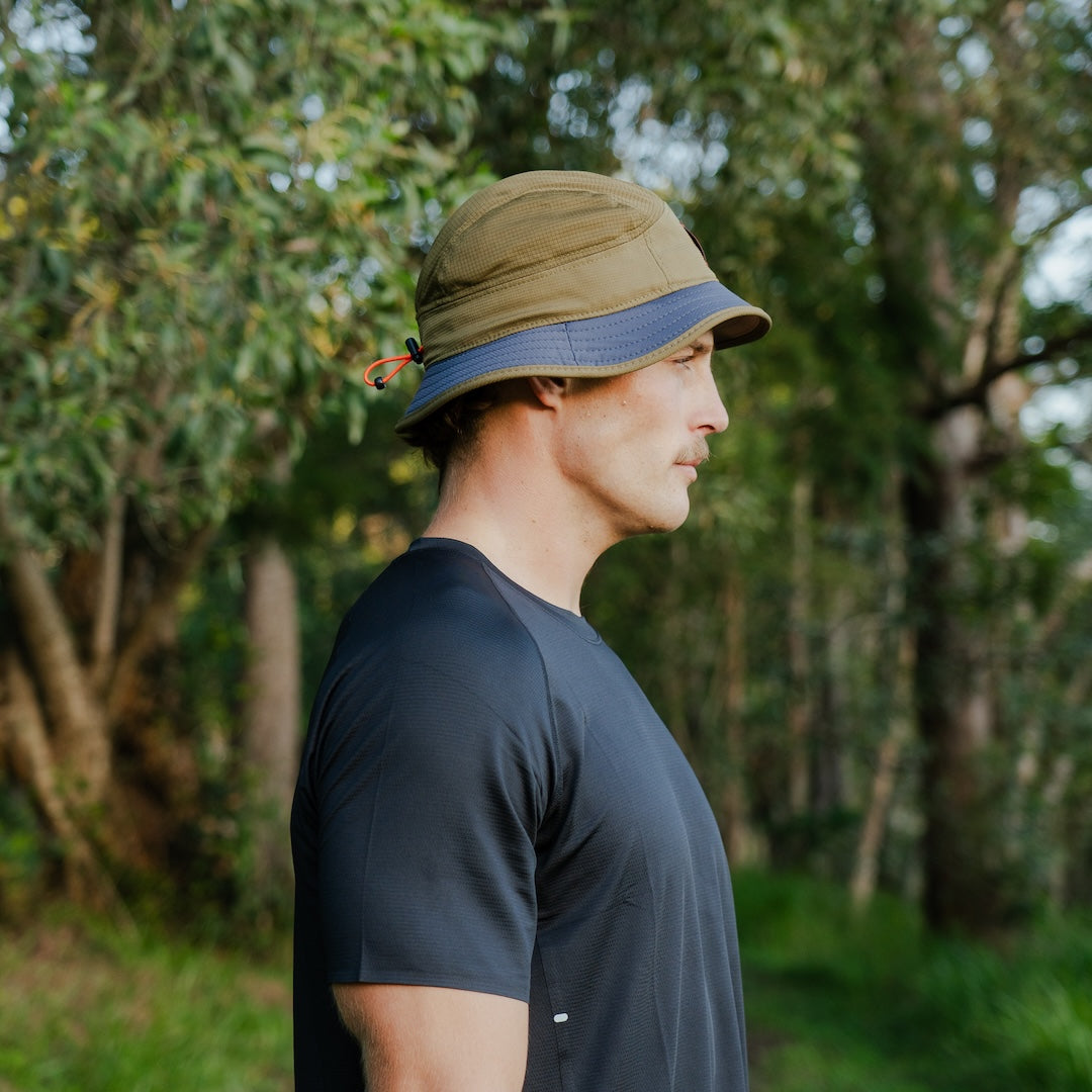 Runner wearing B-THICKET Bucket Hat outdoors, side view