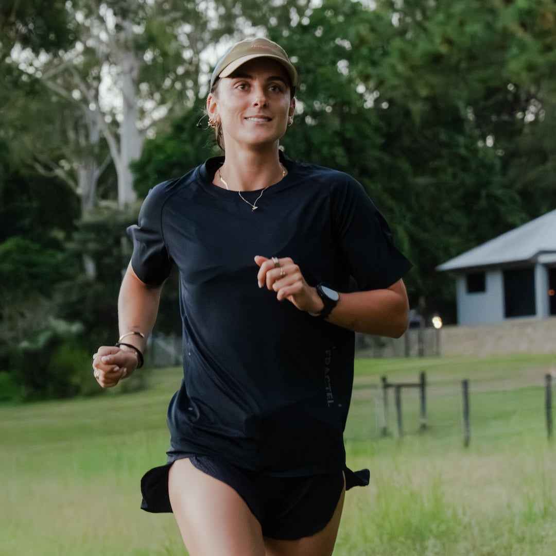 Runner wearing E-TRAILHEAD Cap outdoors