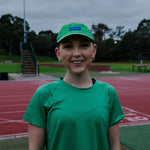Female wearing a green cap and shirt at a track