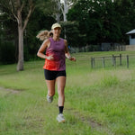 Runner wearing Women's S-EMBER Running Singlet outdoors